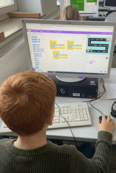 Kursleitung erklärt Programmierung in der AG